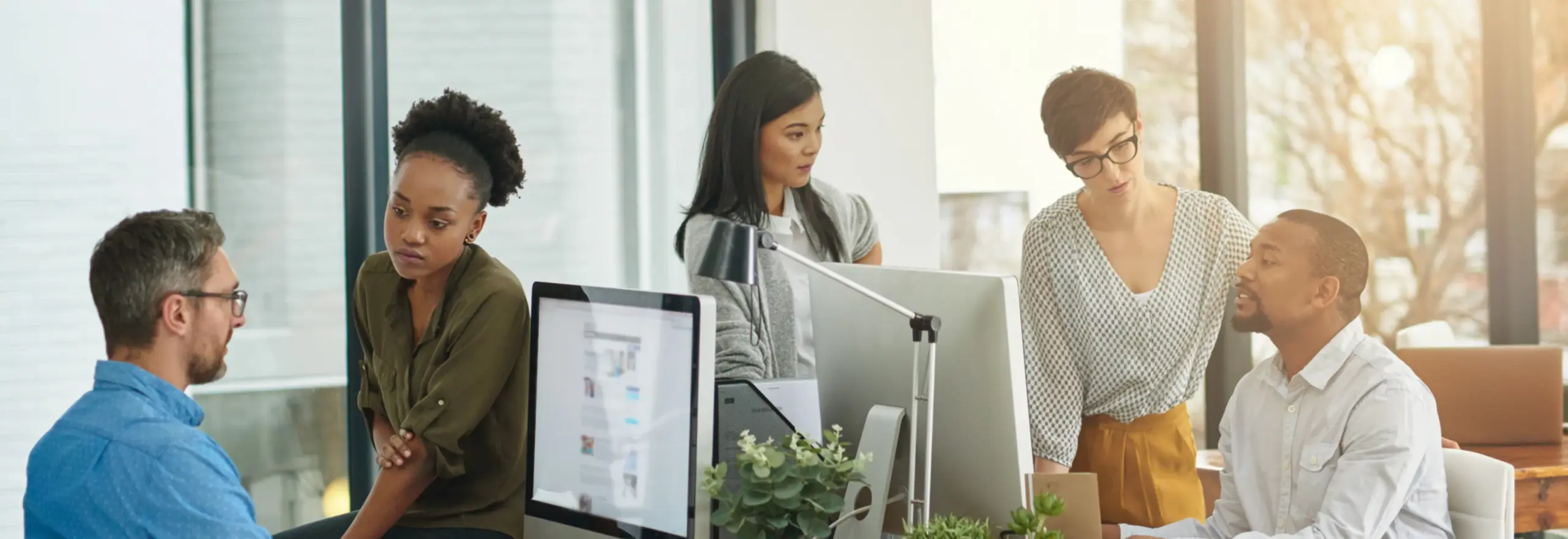 Team collaborating around computers in an office